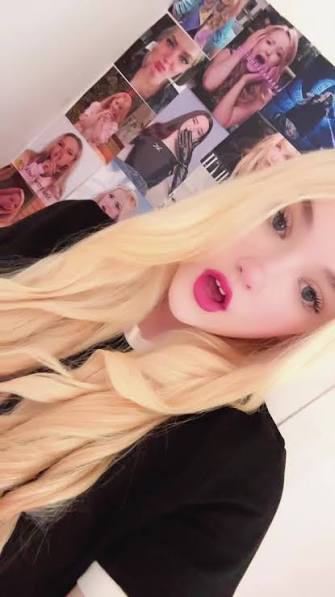 Elizabeth Farrell, the #1 Dovely Girl, in front of her Dove Cameron photo wall